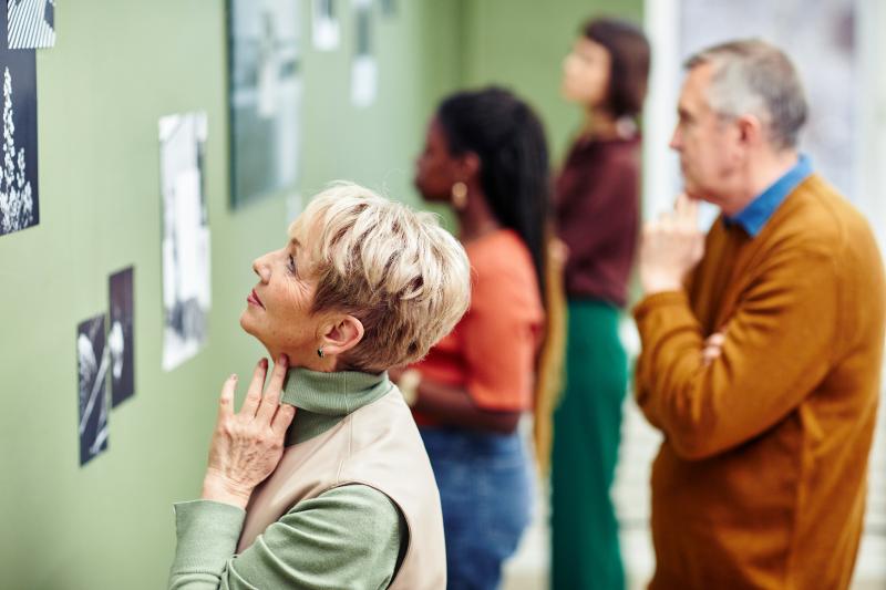 A group of people look at art in an exhibition