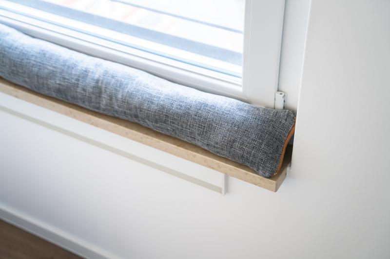 A grey draught excluder on a windowsill