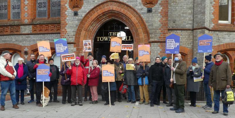 Members of Friends of the Earth Reading gathered outside the town hall holding placards calling for warm homes