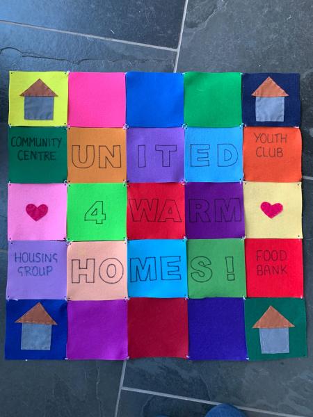 Felt patches tied together to form a quilt with warm homes messages on them