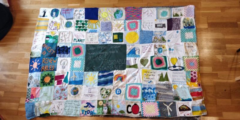 A patchwork quilt with various messages and images on it