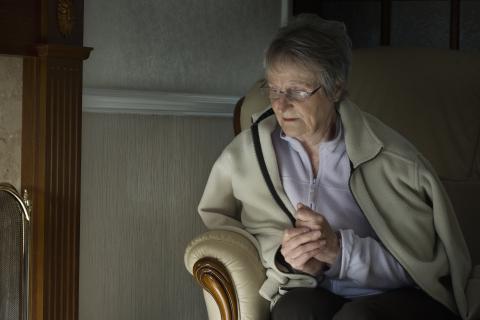 Elderly woman wearing extra layers and looking cold