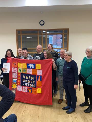Luton Friends of the Earth show their MP their quilt on the Warm Homes Day of Action