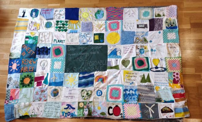A patchwork quilt with various messages and images on it